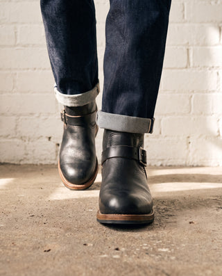 Black 3530 engineer boots front three-quarter mid-stride showing the rounded toe