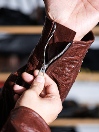 Cuff zipper of the brown Archetype D-Pocket jacket, worn