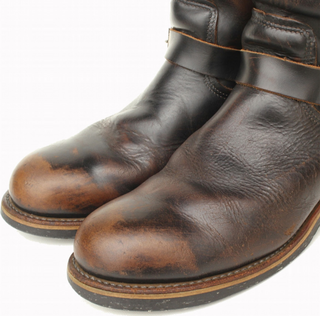 Pair of brown leather boots with visible wear on a white background
