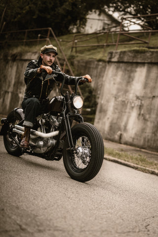 Rider riding past a concrete retaining wall on a back road