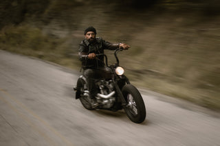 Rider leaning through a bend on a mountain road, background in motion blur