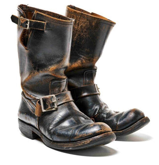 Pair of black leather boots with buckles on a white background